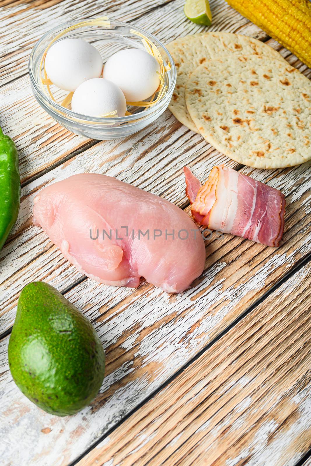 Mexican tacos with vegetables and chicken meat, corna and other ingredients over white textured wooden background , side view with space for text. by Ilianesolenyi