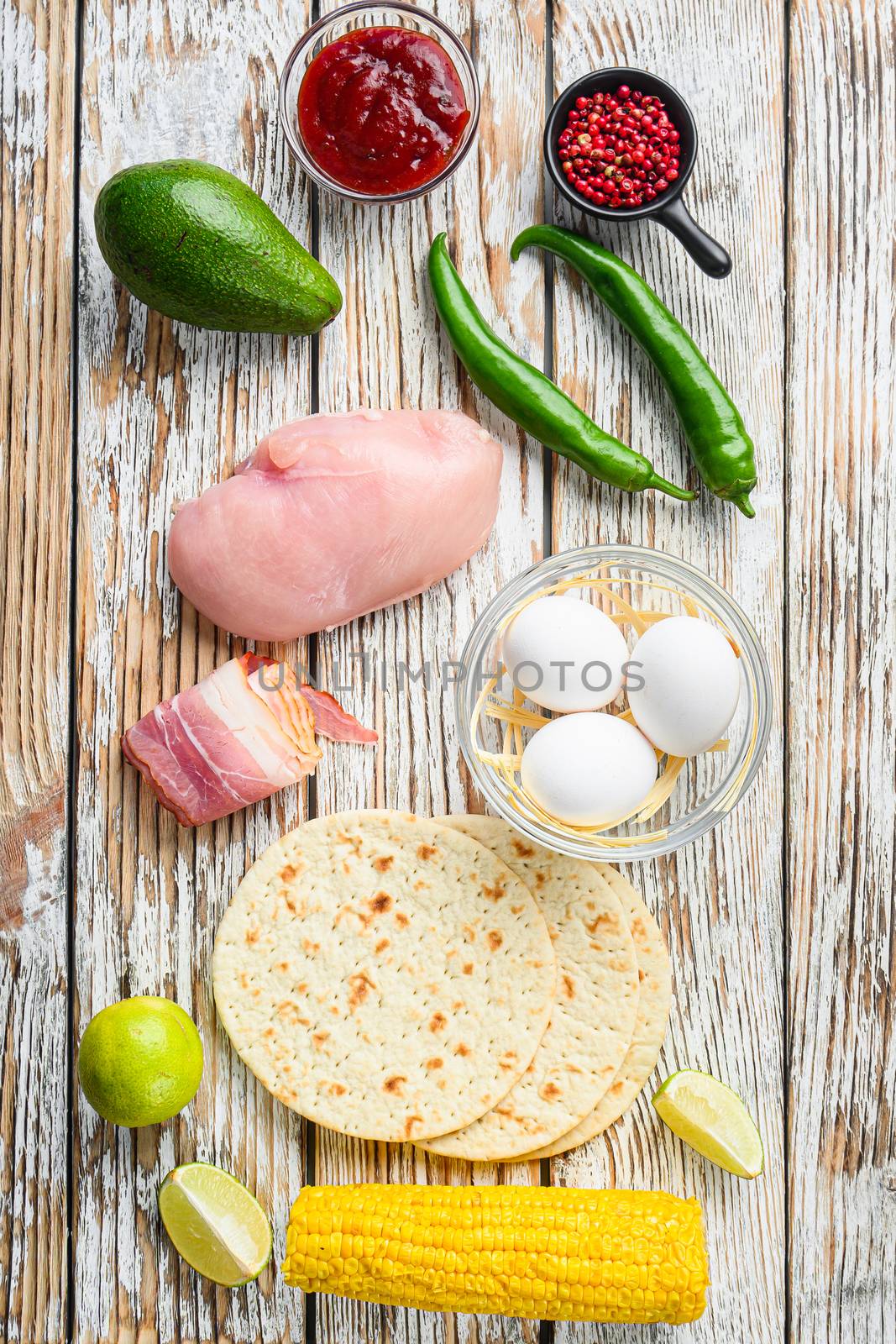 Mexican tacos with vegetables and chicken meat, corna and other ingredients over white textured wooden background , top view