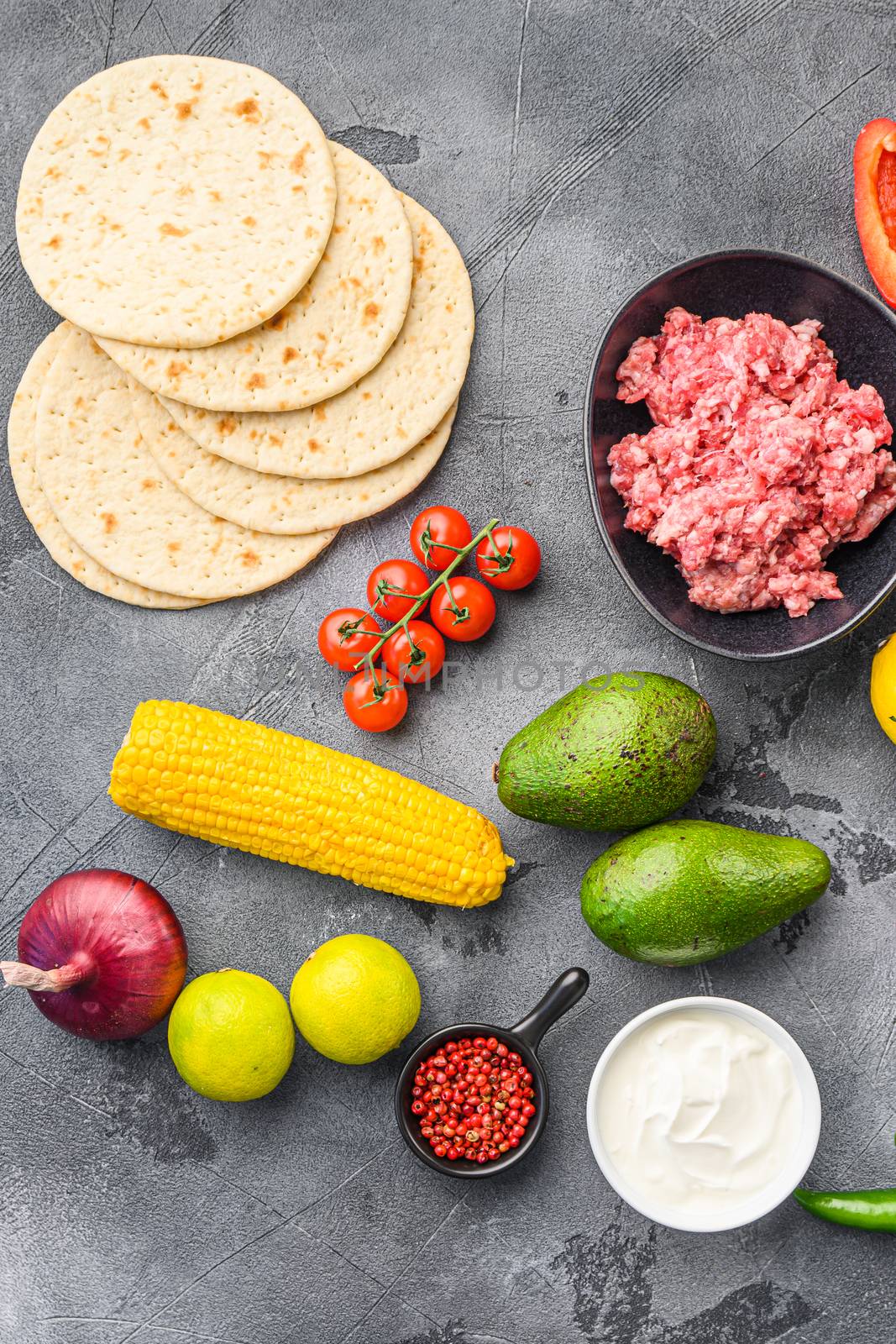 Ingredients for meat mexican tacos , corn tortillas, chili pepper, avocado, meat on textured grey background, top view. by Ilianesolenyi