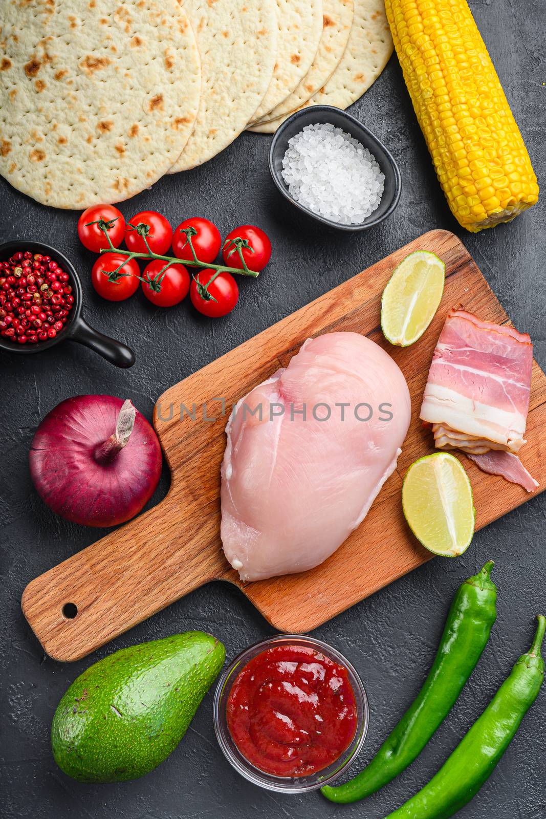 Ingredients for Mexican tacos with chicken meat, corn tortilla, salsa, chilli over black background, top view. by Ilianesolenyi