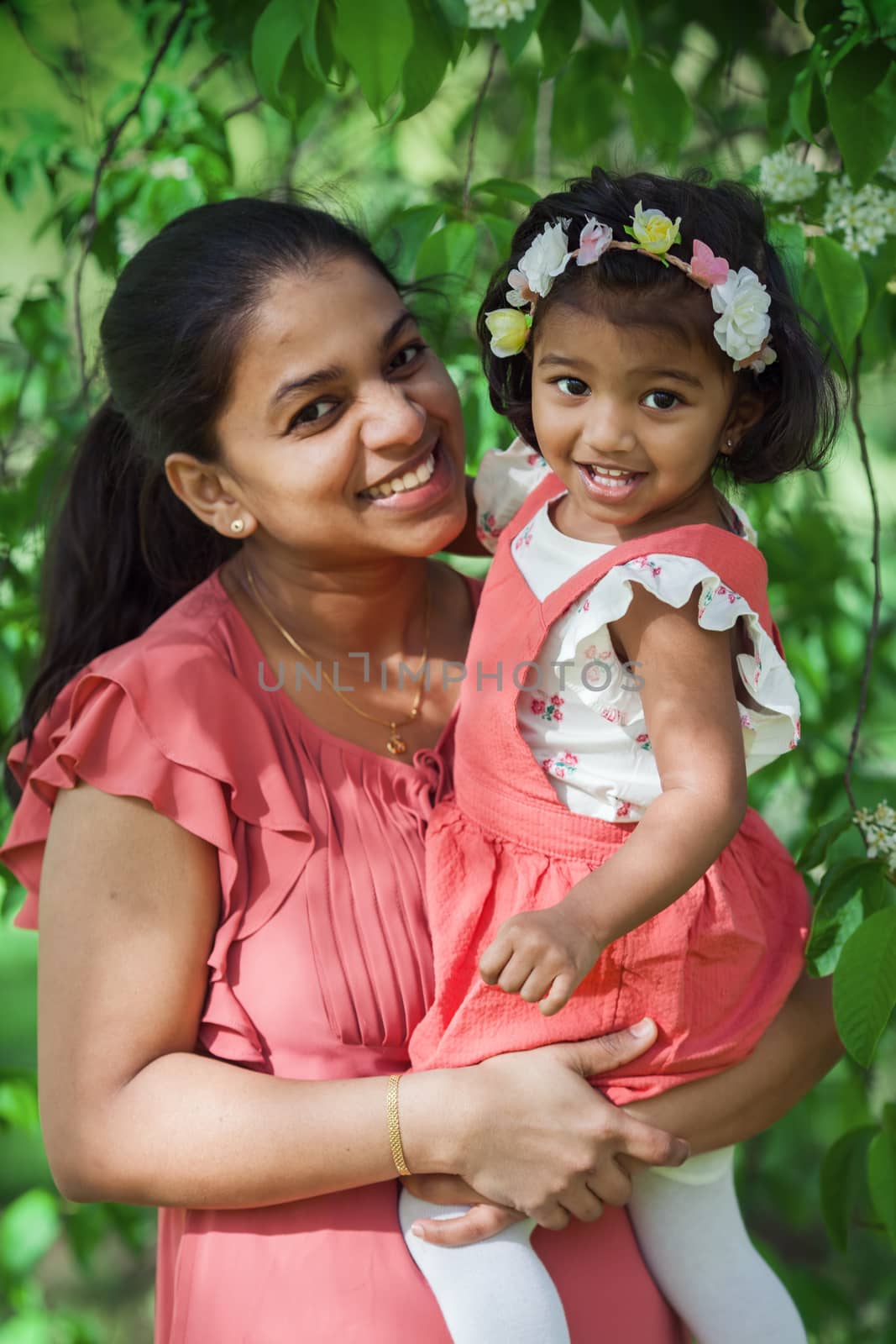 A happy south asian woman with two years old girl in spring park by anry