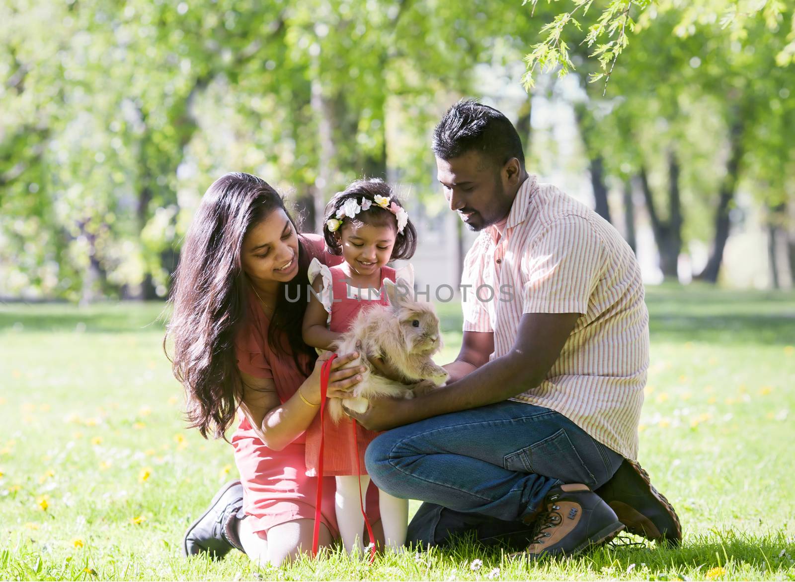 A South Asian happy young family is walking in city park by anry