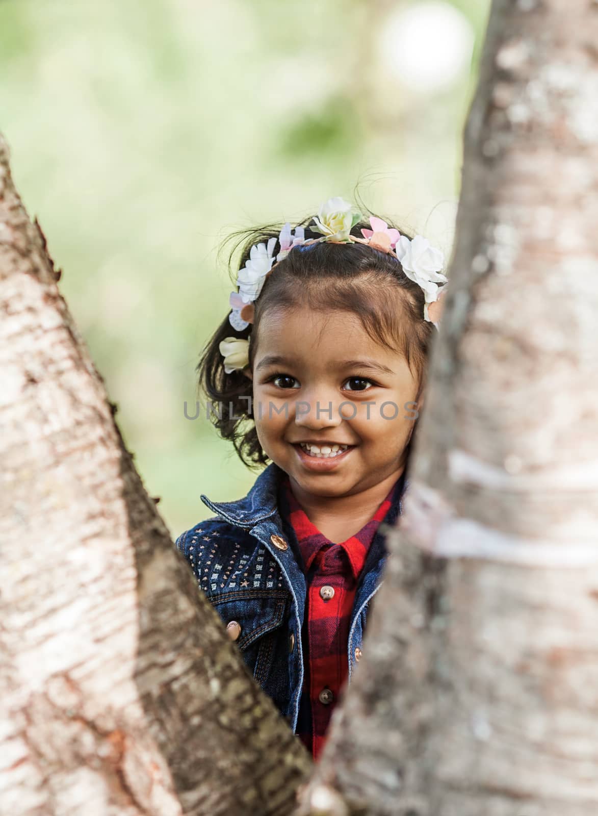 A smiling little girl is playing in park by anry