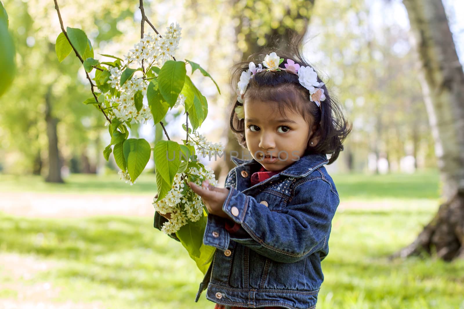 A happy south asian girl is walking in city park by anry