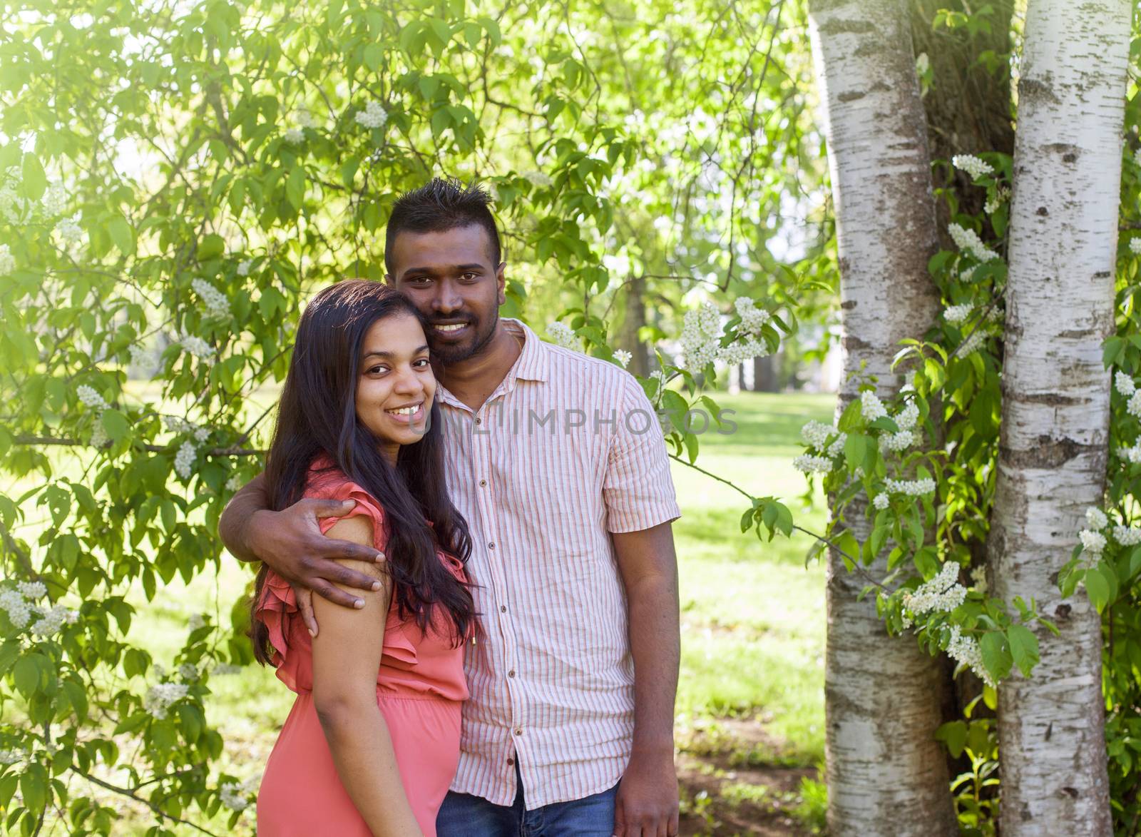 A south asian happy young couple is walking in city park by anry