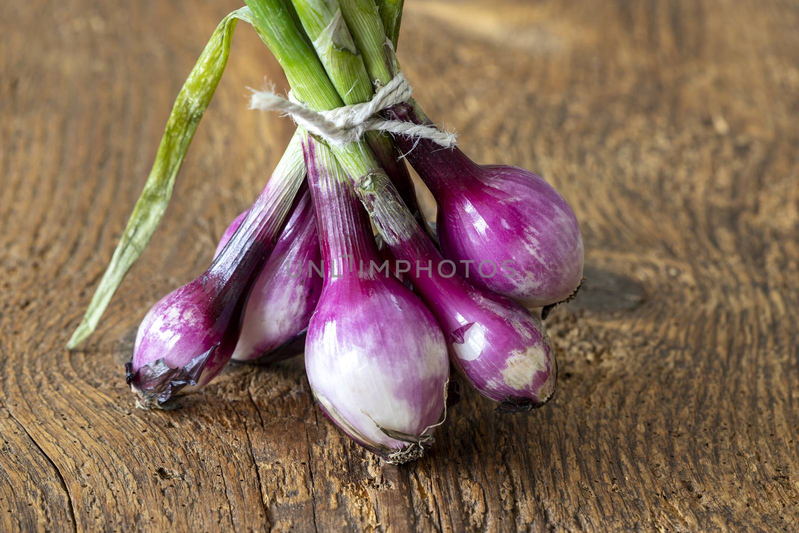 bunch of purple onions on wood