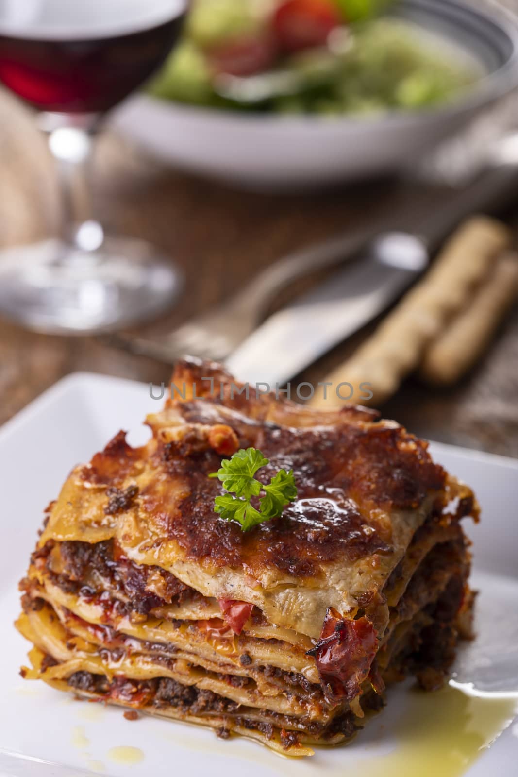 portion of lasagna on a plate by bernjuer