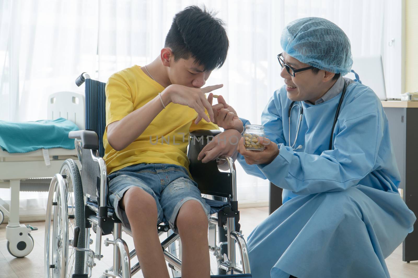 Asian Volunteer Doctors Caring and Helping Rehabilitation of Disabled Boys Stay at the hospital. The boy is crippled, Asian people can't help themselves. Must sit in a wheelchair all the time