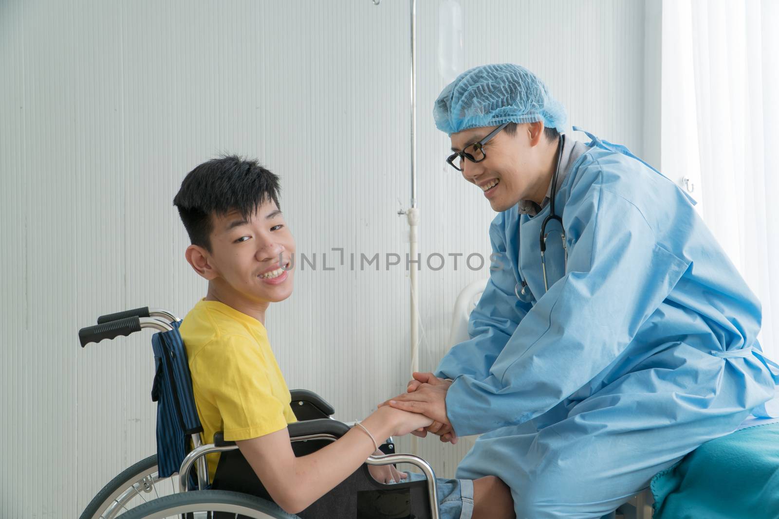 Asian Volunteer Doctors Caring and Helping Rehabilitation of Disabled Boys Stay at the hospital. The boy is crippled, Asian people can't help themselves. Must sit in a wheelchair all the time