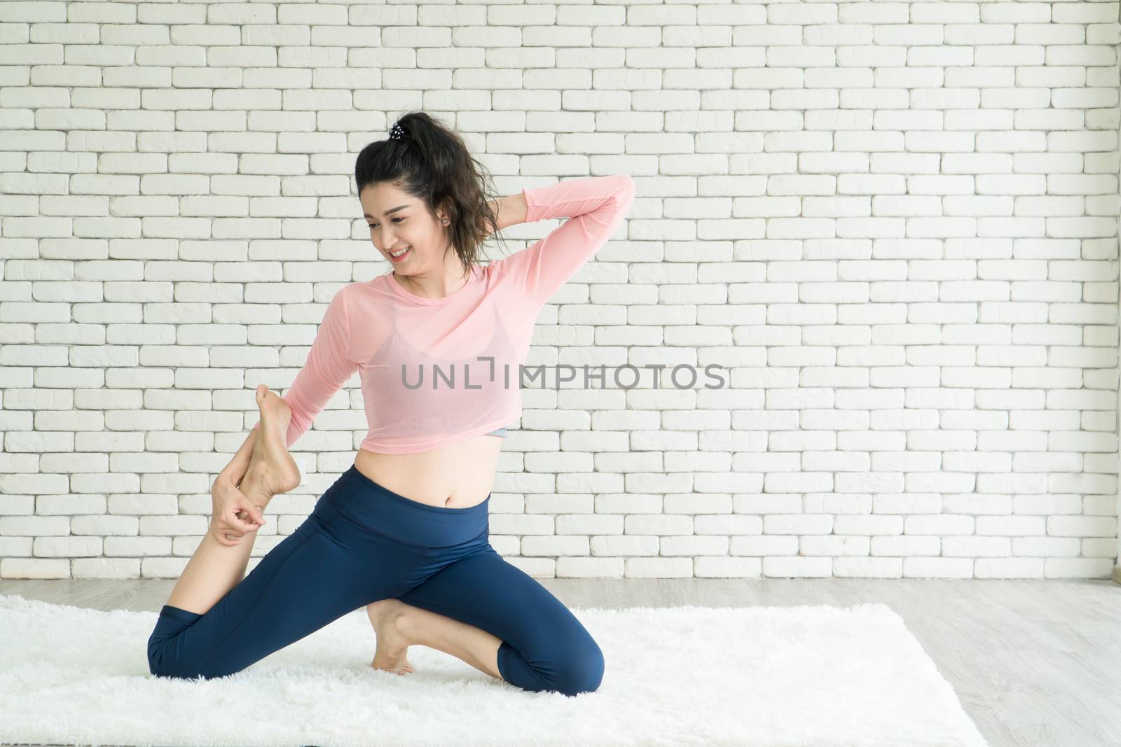 Attractive and healthy woman Asian are exercising Stretching with yoga postures at home helps to balance life.copy space is on the left side of the image For adding text