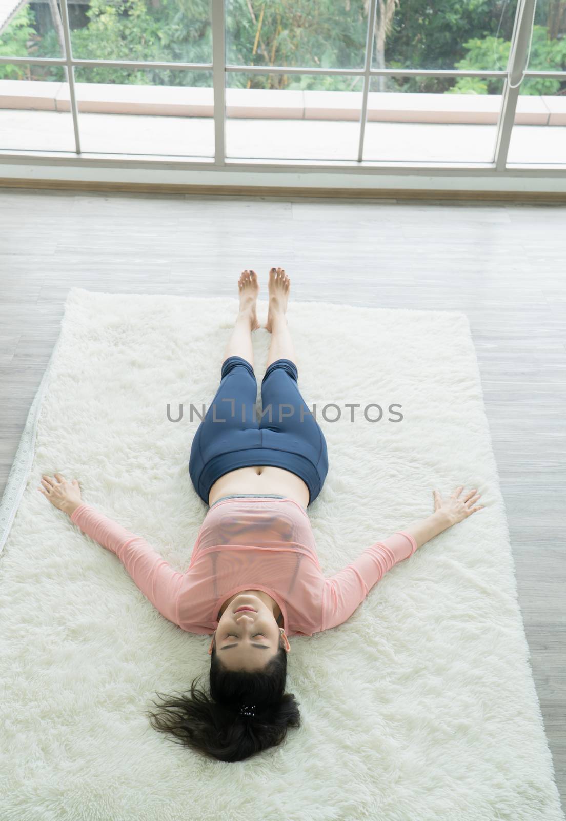 Beautiful Asian women stretching at home. by nuad338