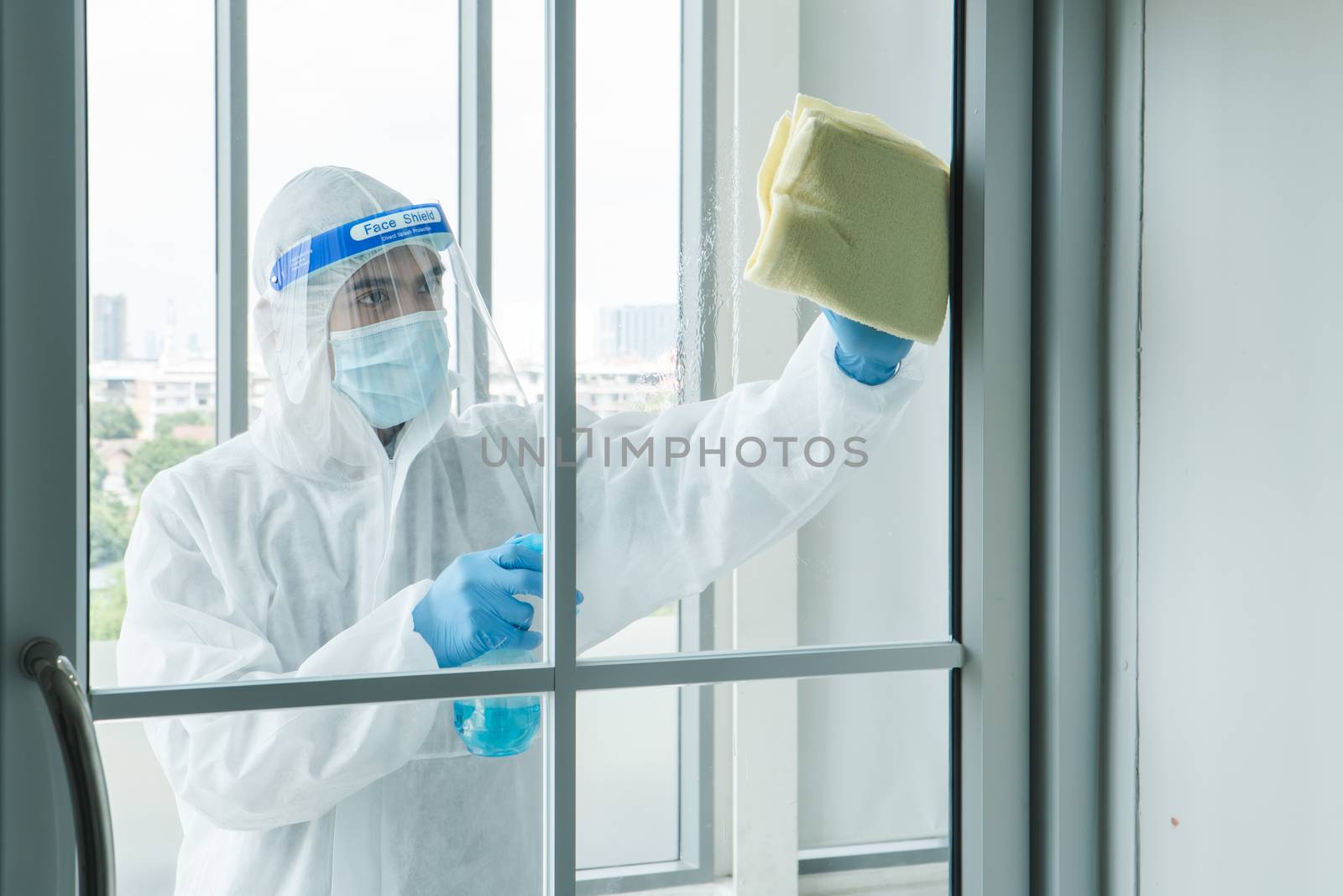 Workers wear protective clothing and wear a mask. Spraying disinfectants for cleaning inside the building. Cleaning service professionals are becoming popular After the spread of coronavirus