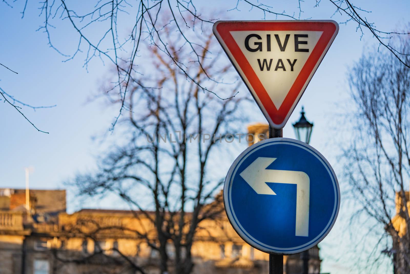 A give way sign and left turn road sign in England