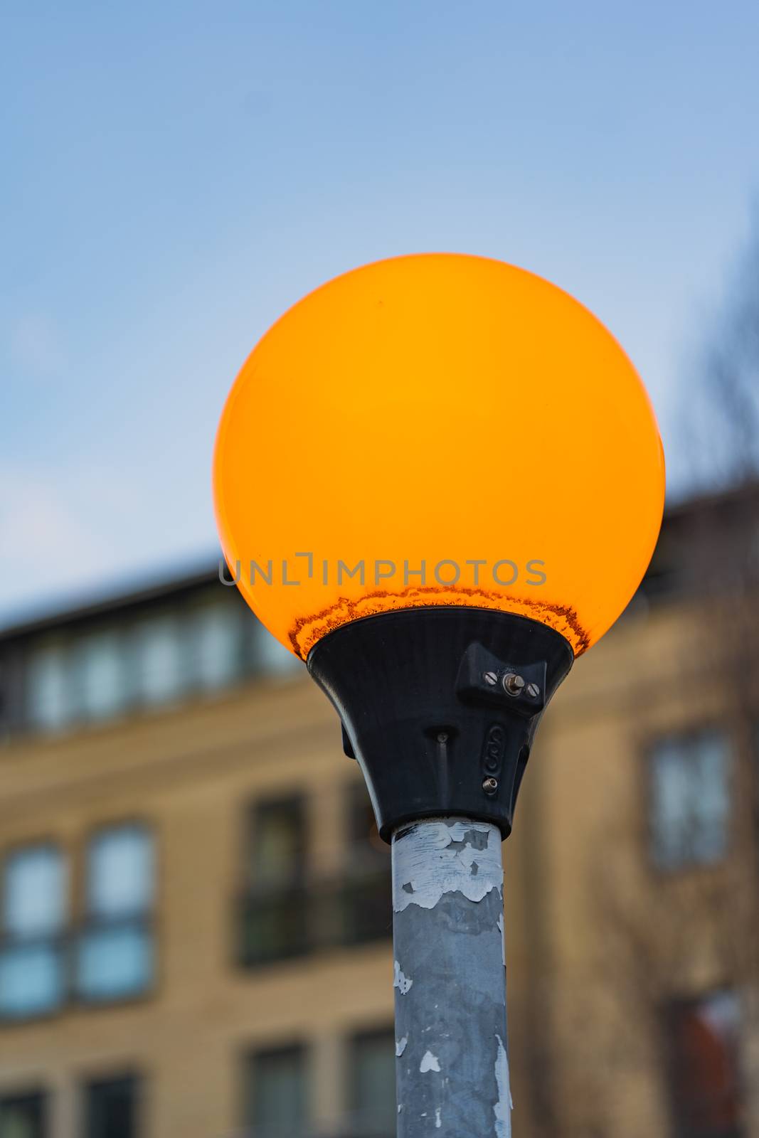 A close up of an orange illuminated zebra crossing light in England