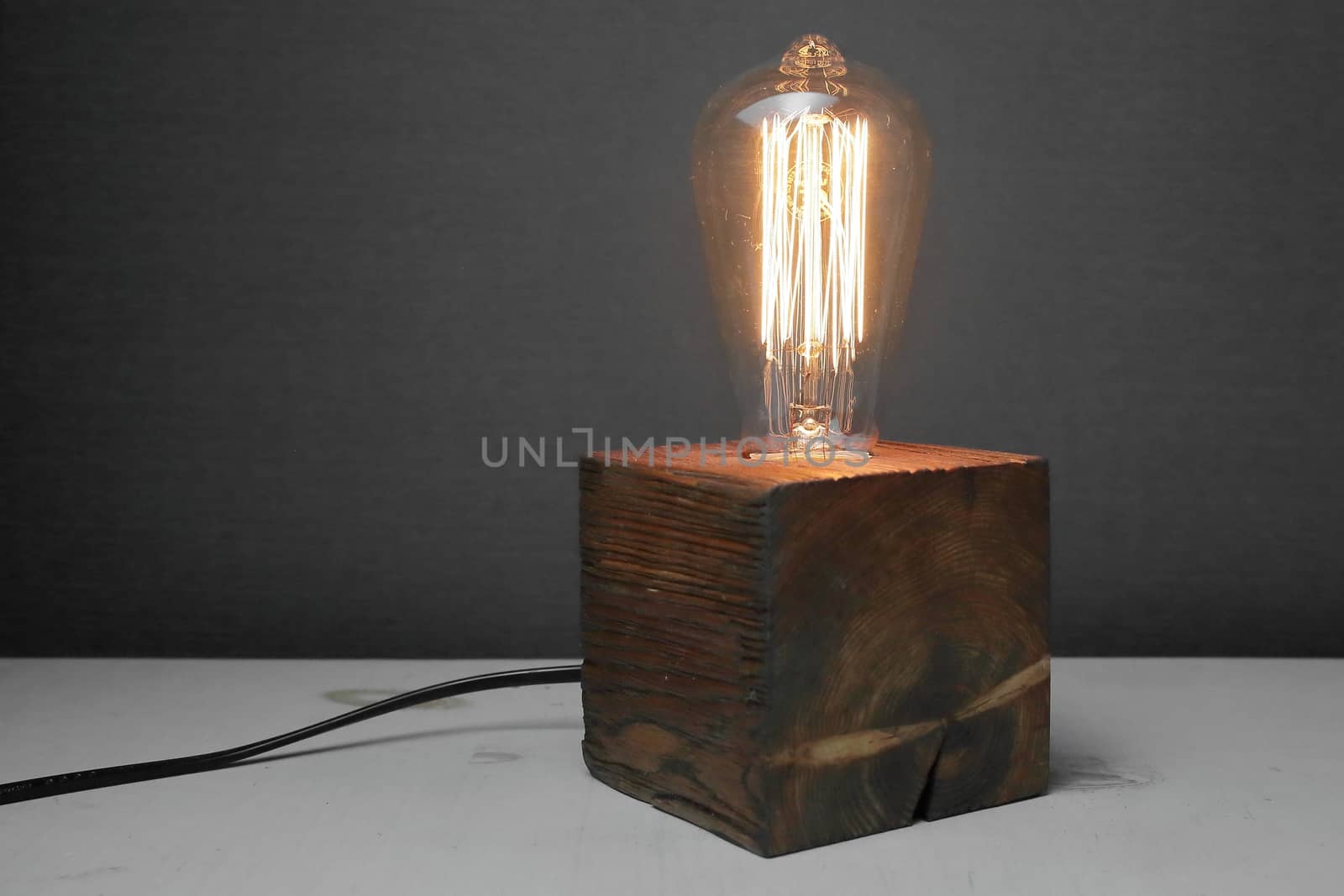 Retro wood lamp with Edison lamp on a gray background. The concept is a good idea. High quality photo