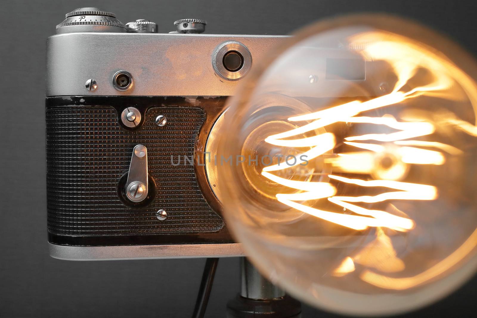 Retro lamp from an old camera with an Edison lamp on a gray background. Concept is a good idea. High quality photo