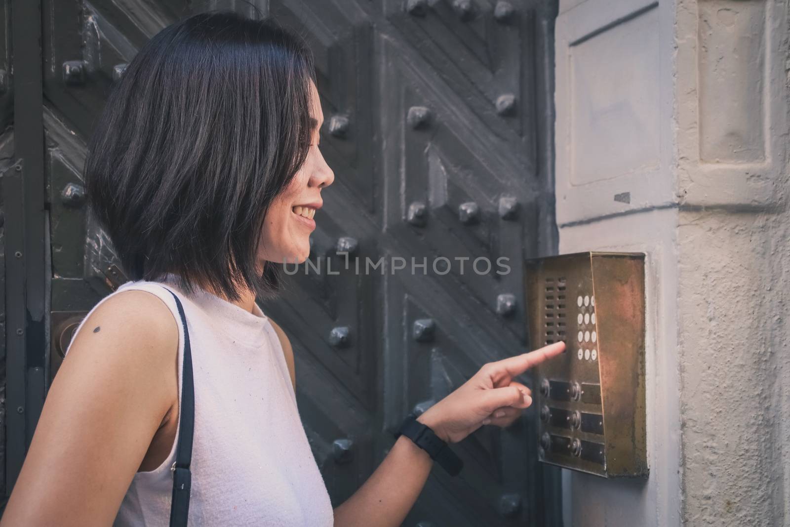 Girl that is pushing a button of the house intercom outdoors in  by anotestocker