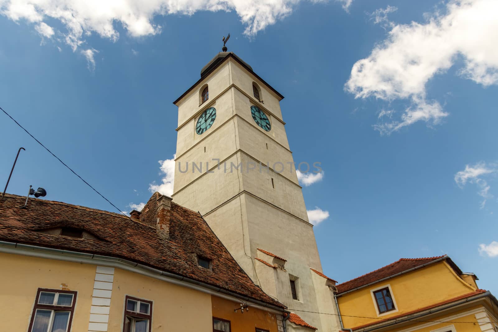 SIBIU, ROMANIA - Circa 2020: Old medieval town with cloudy blue sky. Beautiful tourist spot in eastern central Europe. Famous Tower of Council in Sibiu Romania by dugulan