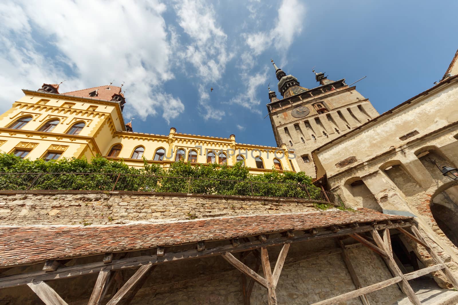 SIGHISOARA, ROMANIA - Circa 2020: Old medieval town with cloudy blue sky. Beautiful tourist spot in eastern central Europe. Famous old medieval Clock Tower in Sighisoara Romania by dugulan