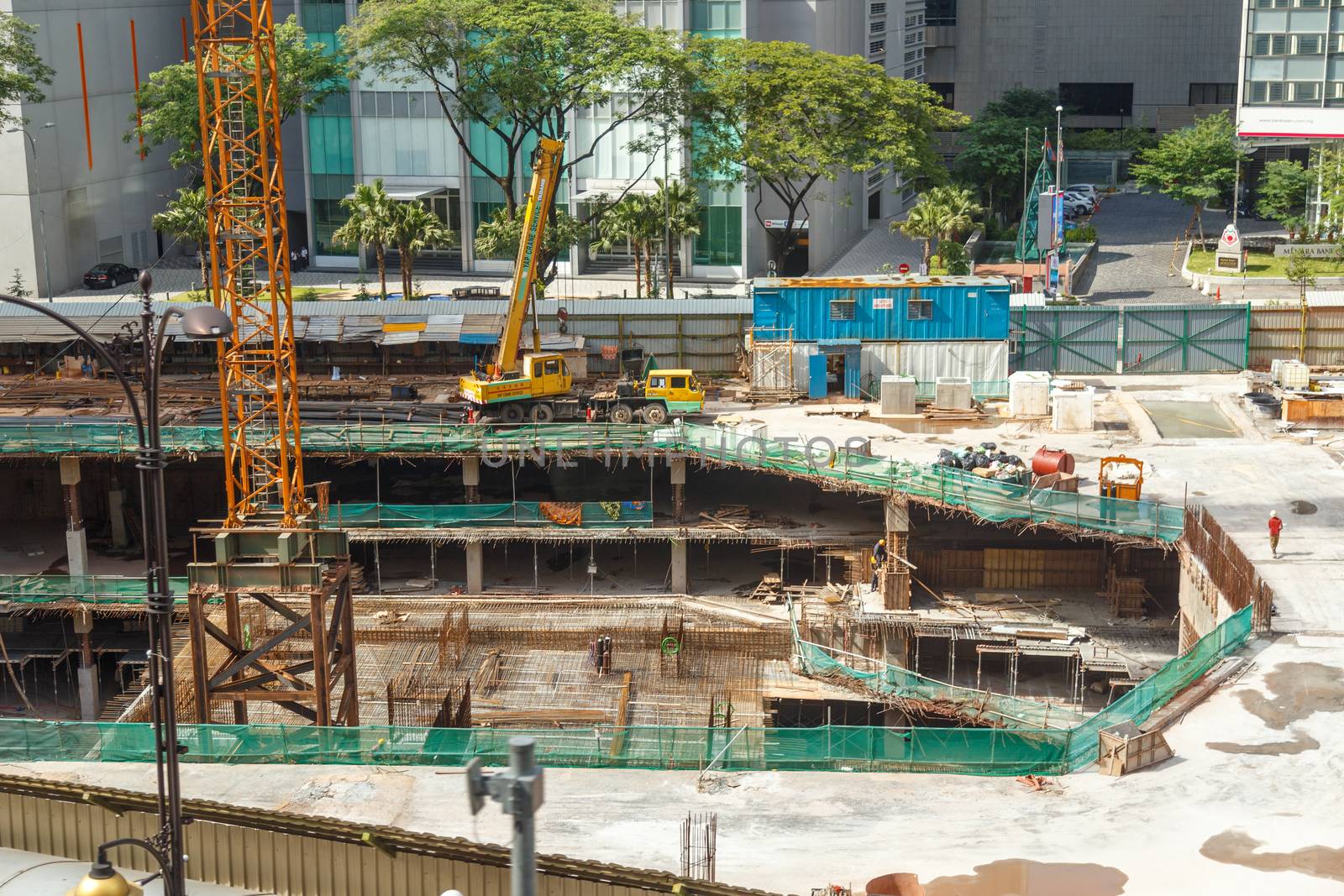 HONG KONG, CHINA - CIRCA 2020: Skyscraper excavator dismantling a building in Hong Kong. Huge Construction site. Concept of urban modern development site constriction by dugulan