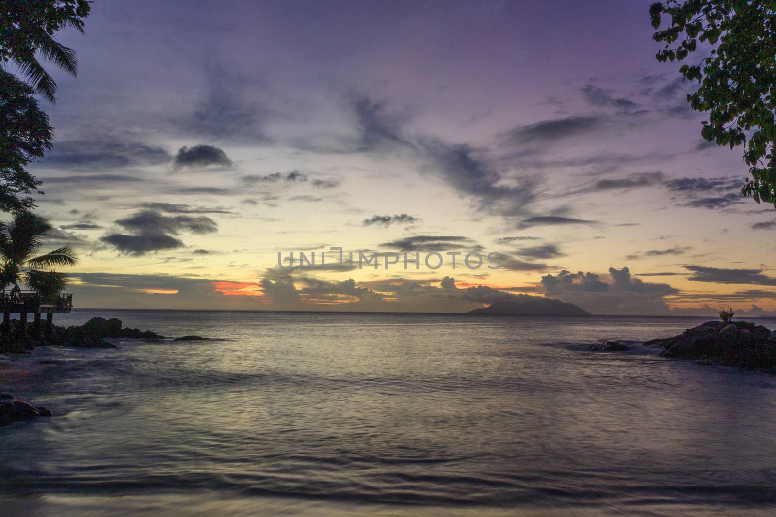 Landscape beautiful colorful golden sunset red, orange and purple sky Seychelles. Serenity and calm concept. The sun sets behind the horizon on a cloudy day. by dugulan