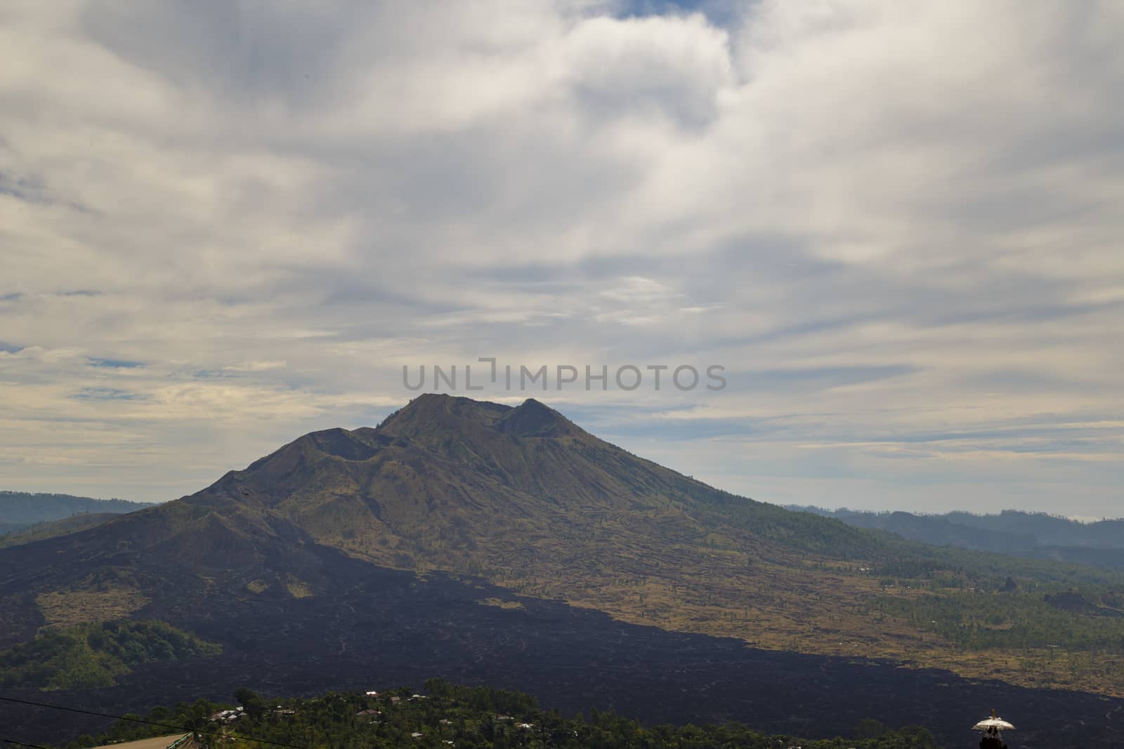View of Indonesia Batur active vulcano with black lava all around.