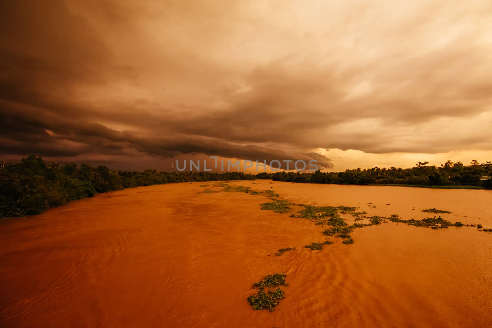 A stunning sunset with storm in the distance on the Mekong River near Can Tho in Vietnam