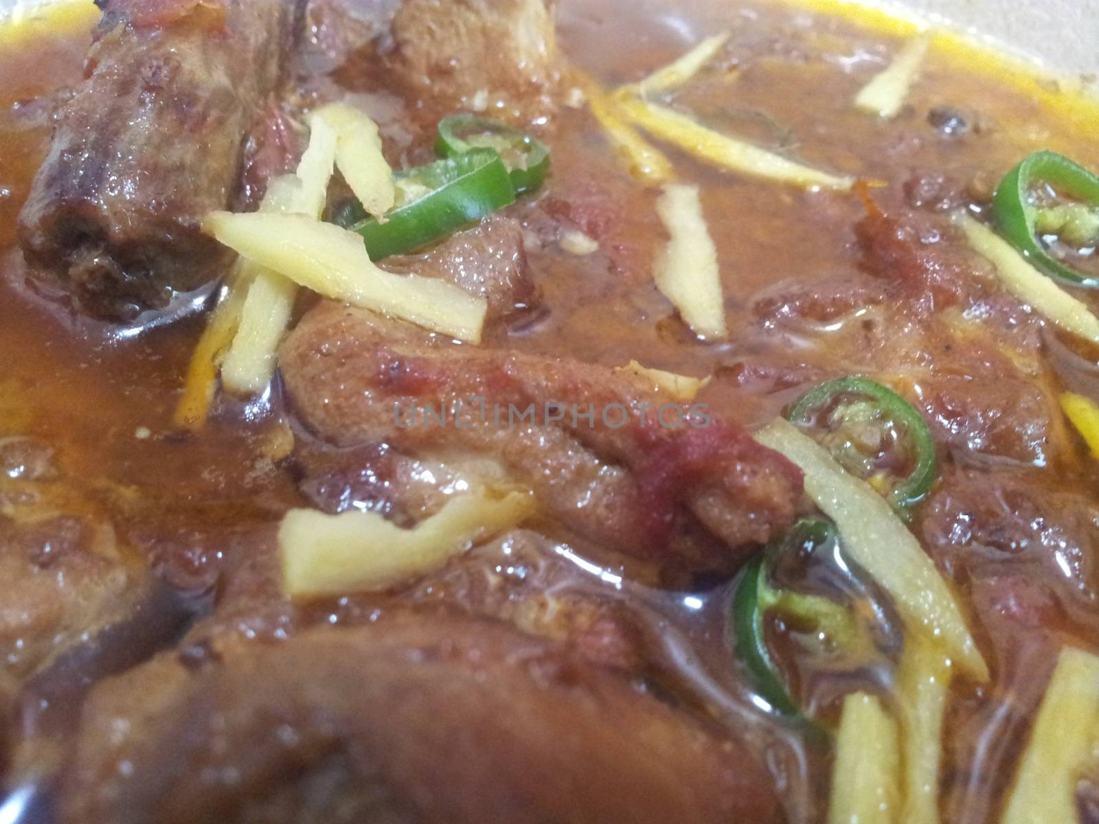 Delicious traditional haleem dish with blackish fried onion rings by Photochowk