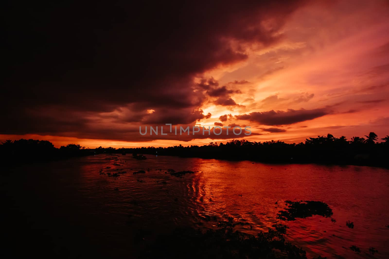 A stunning sunset with storm in the distance on the Mekong River near Can Tho in Vietnam