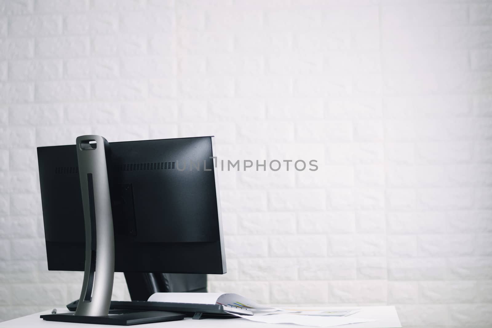 Work desks and computers with documents on the table.