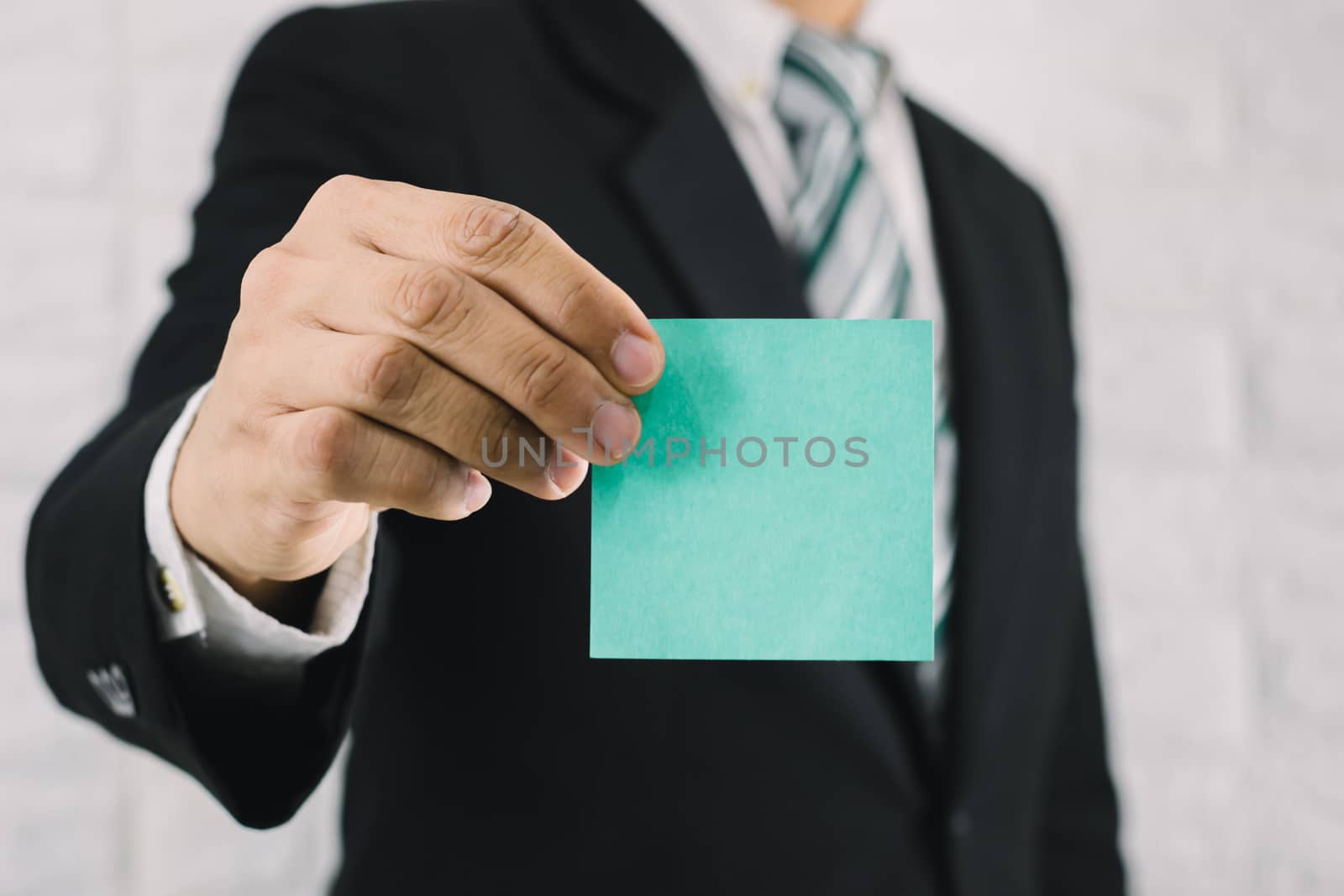 Business man holding card paper post-it notes by sompongtom