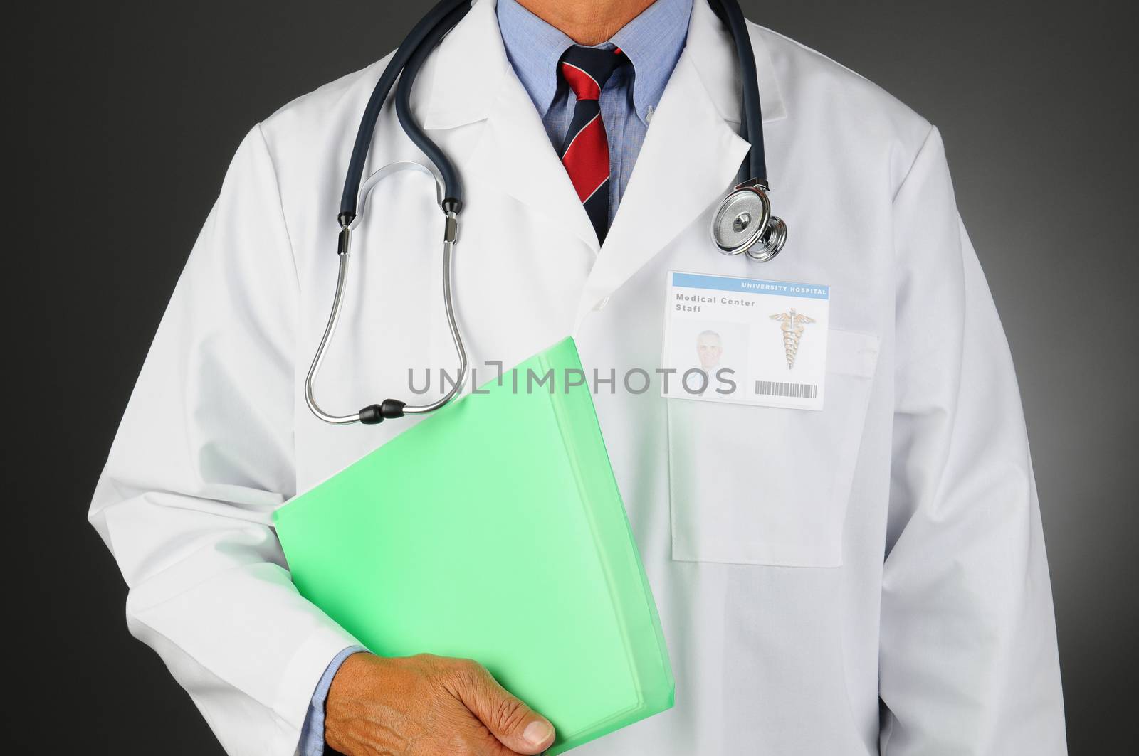 Closeup of a Middle Aged Medical Professional with a stethoscope around his neck holding a patients files. Man is unrecognizable, Id Badge shows his picture. Horizontal  on a light to dark background.