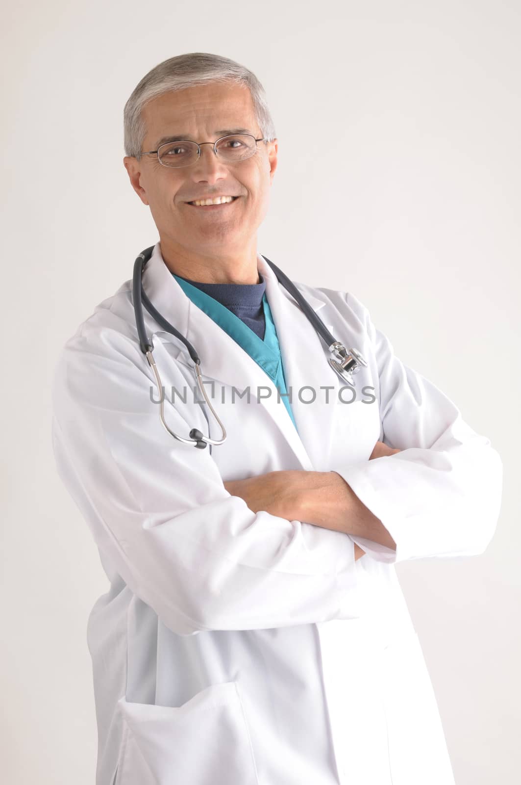 Middle Aged Doctor in Lab Coat and Scrubs with Arms Folded vertical format over gray background