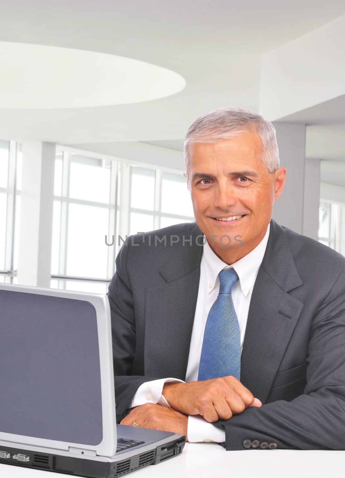 Businessman With laptop at Desk by sCukrov