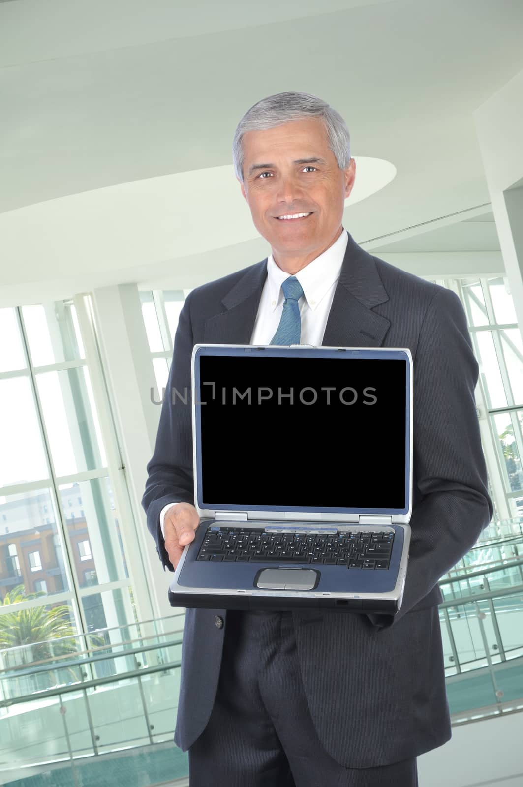 Middle aged Businessman with Laptop Computer by sCukrov