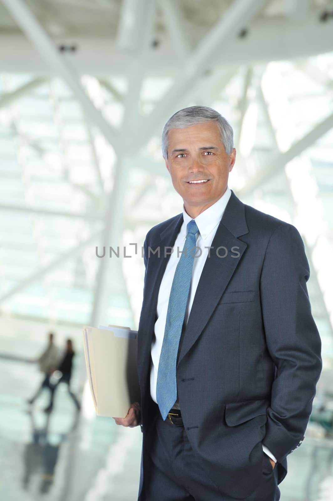 Middle aged Businessman in Lobby with Folder by sCukrov