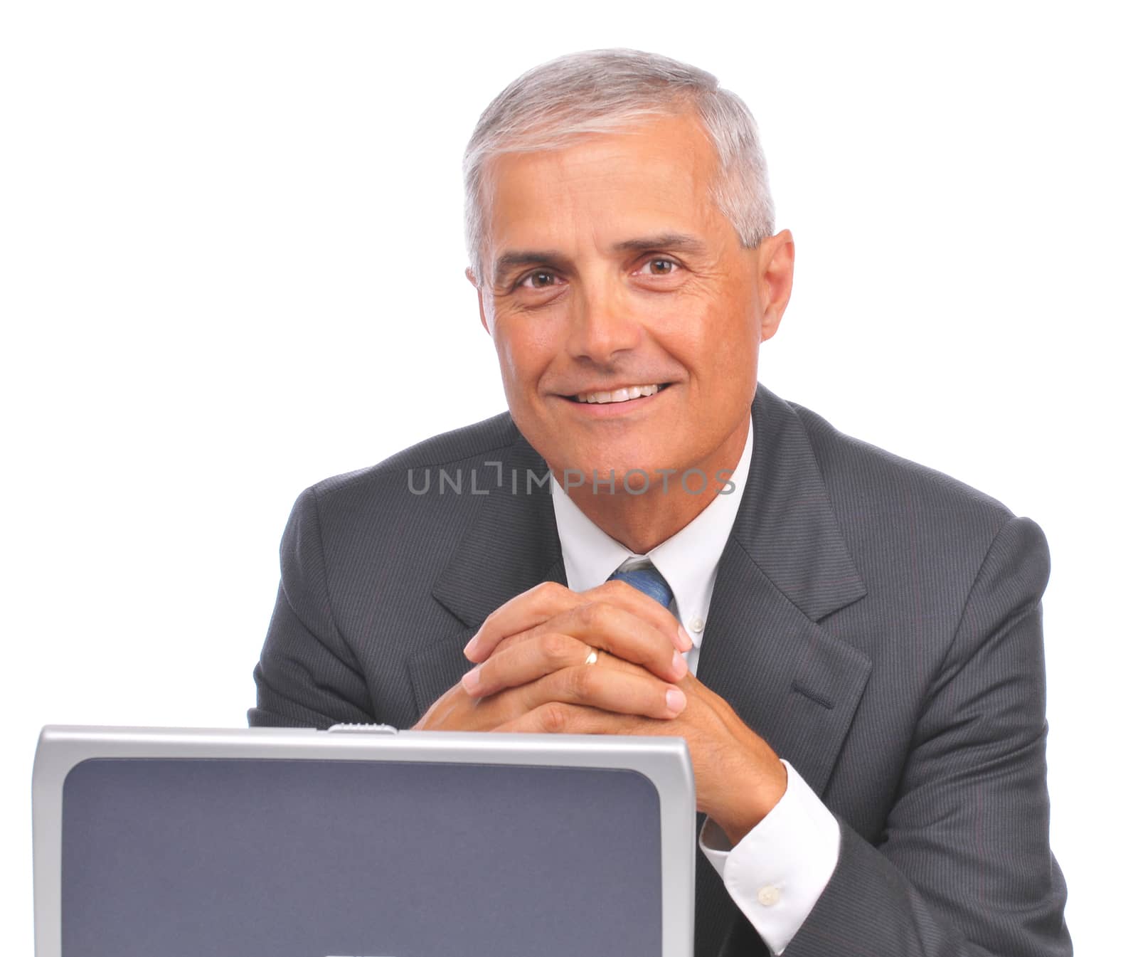 Mature Businessman seated looking over top of laptop isolated on white