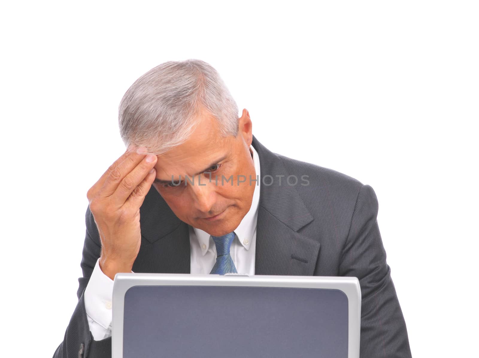 Businessman seated looking over top of laptop by sCukrov