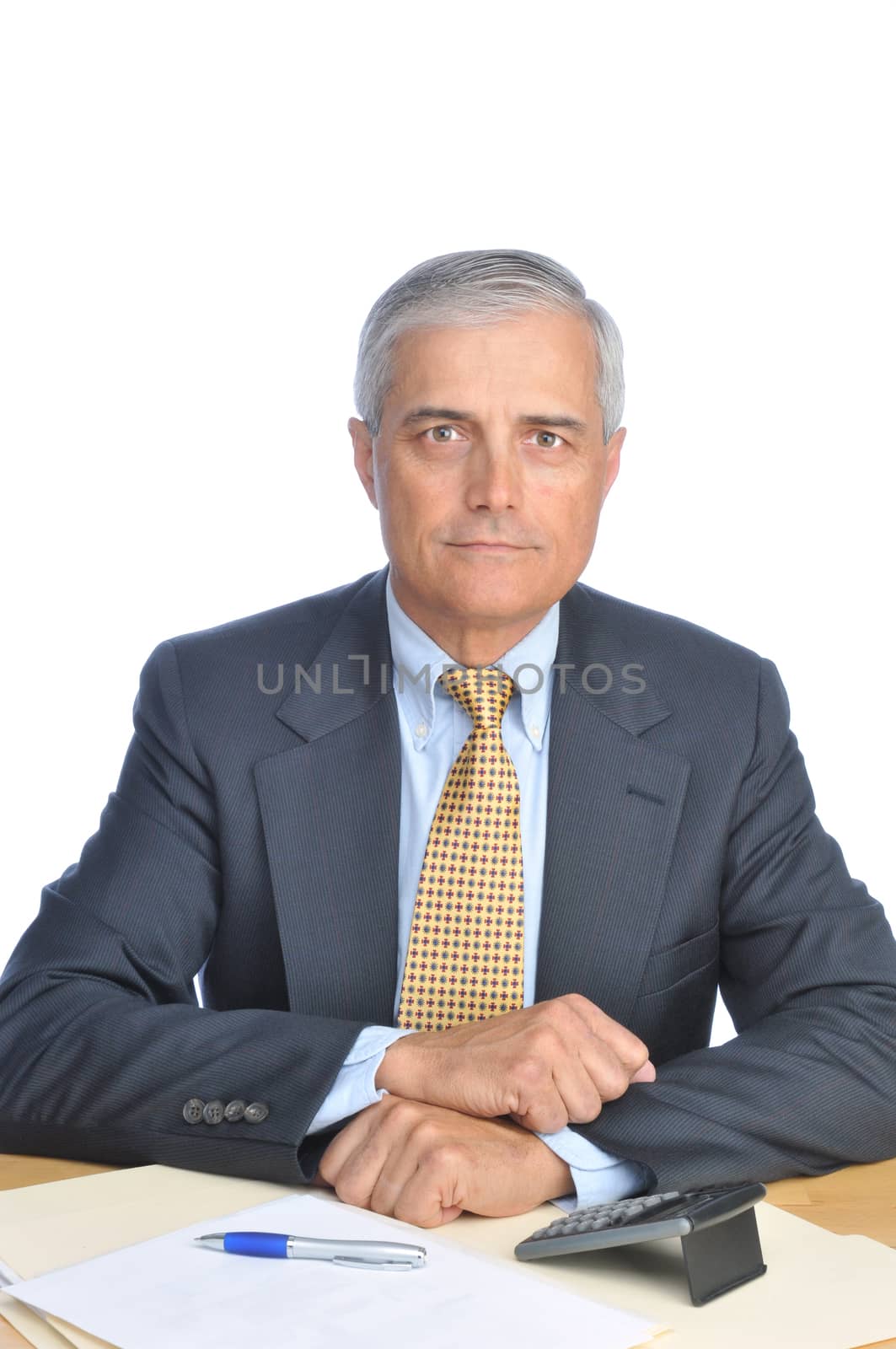 Middle aged Businessman seated at Desk on white background vertical format