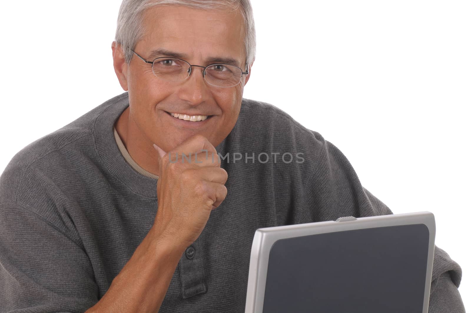 Portrait of a middle aged caucasian man looking over the top of his laptop computer. Man is wearing casual attire and smiling with chin in his hand. Close crop in horizontal format isolated on white.