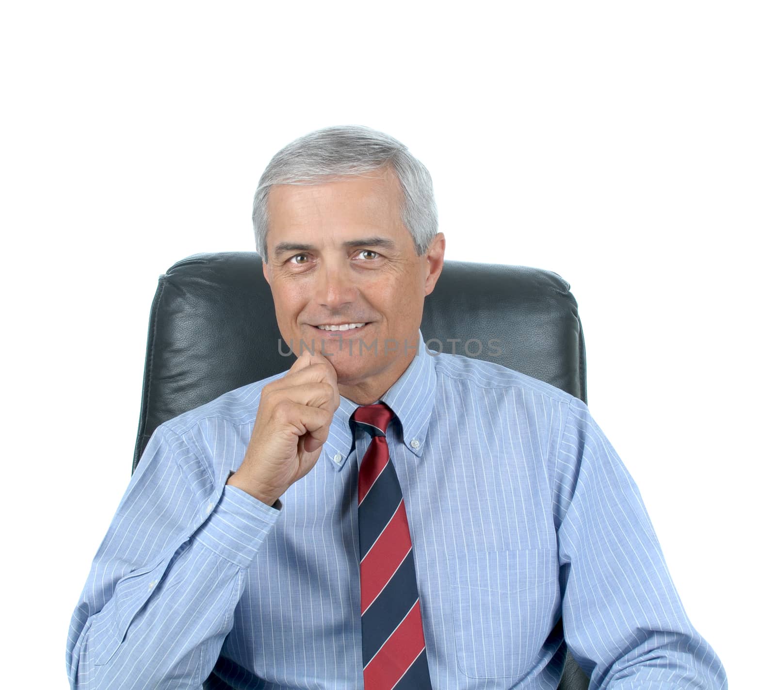 Middle aged businessman seated at his desk with his hand on chin. Square format isolated on white.