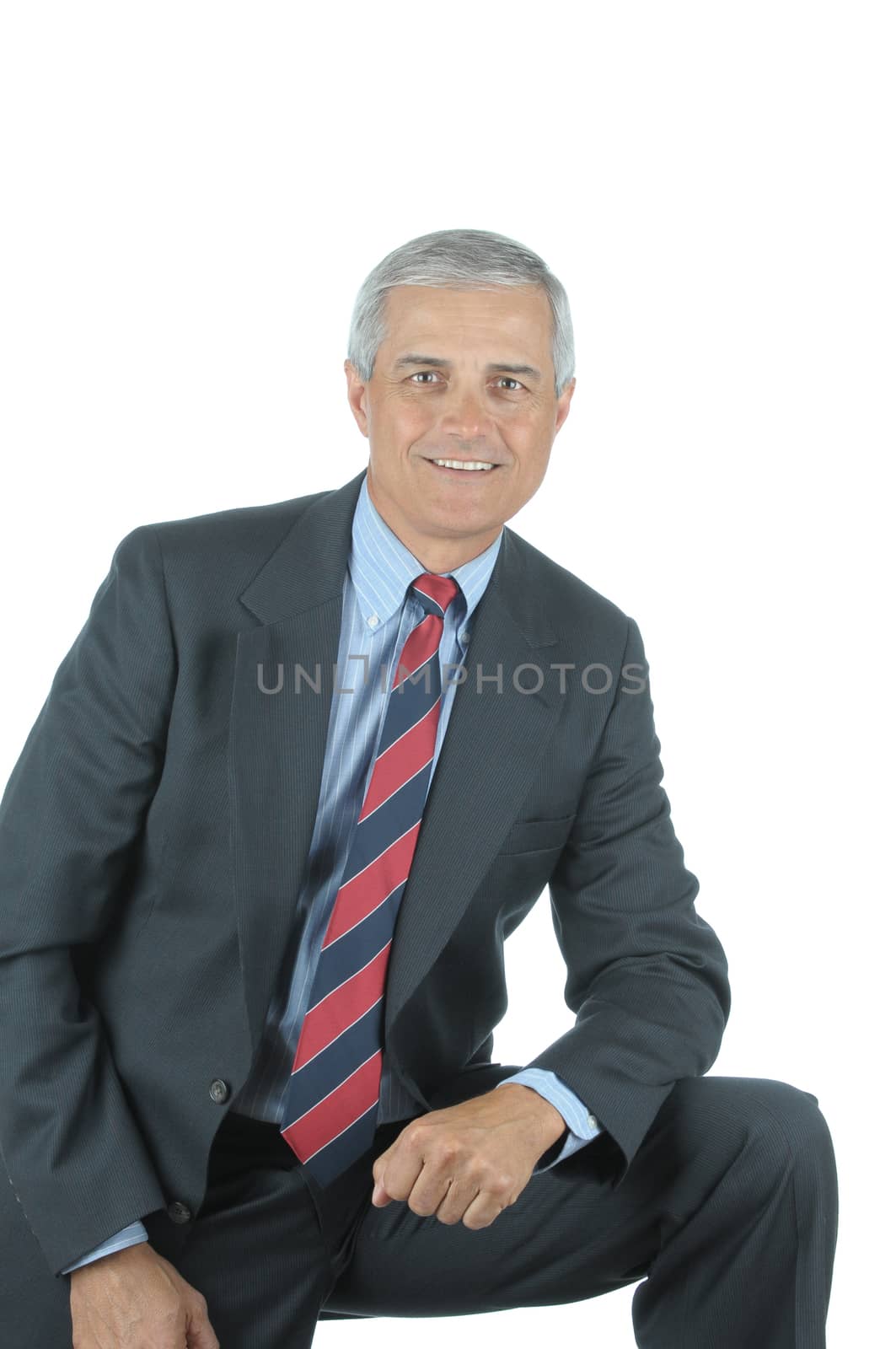 Smiling Middle aged Businessman leaning on one knee isolated on white