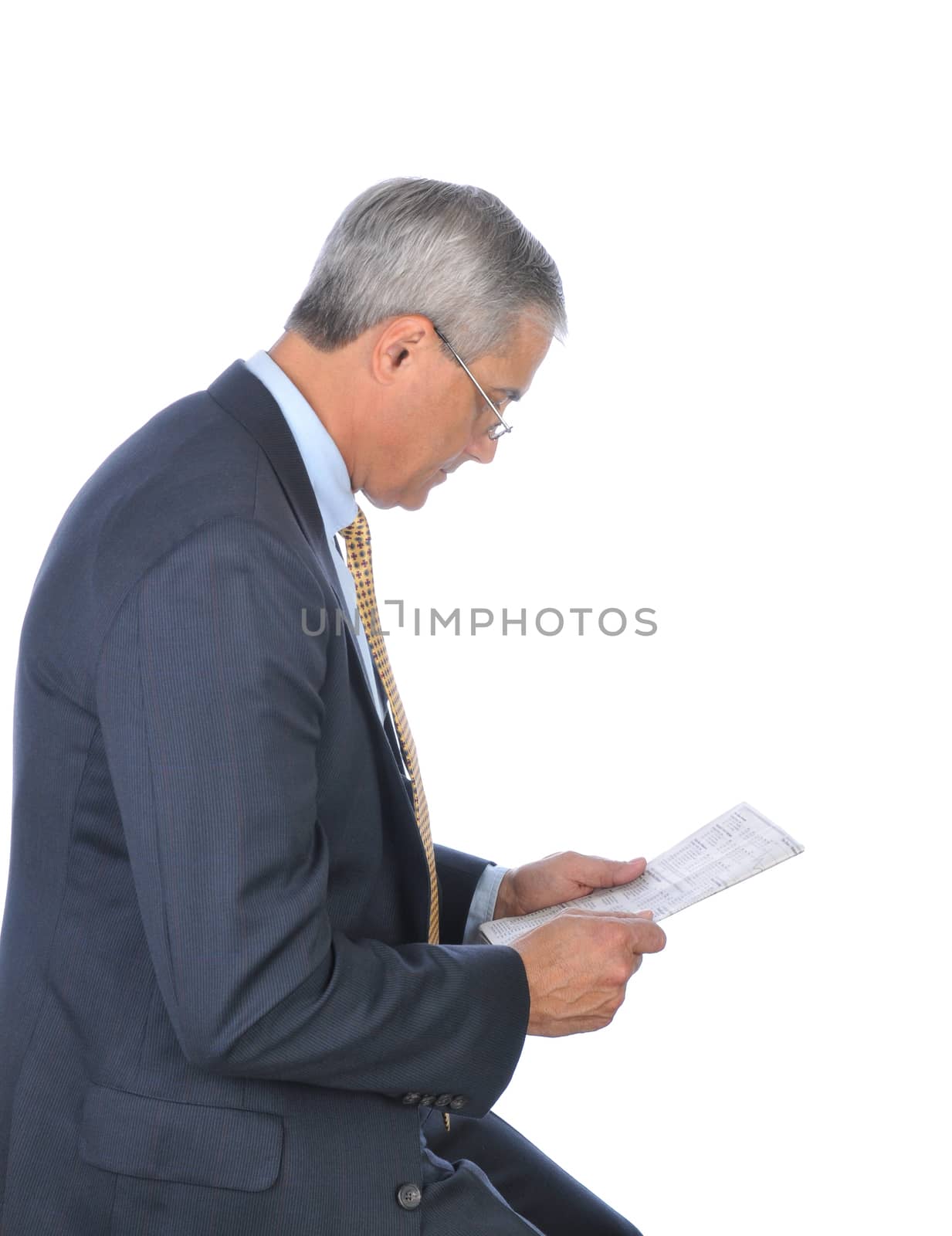Profile of a Middle Aged Businessman Reading the financial section of a Newspaper. Vertical format isolated on white.