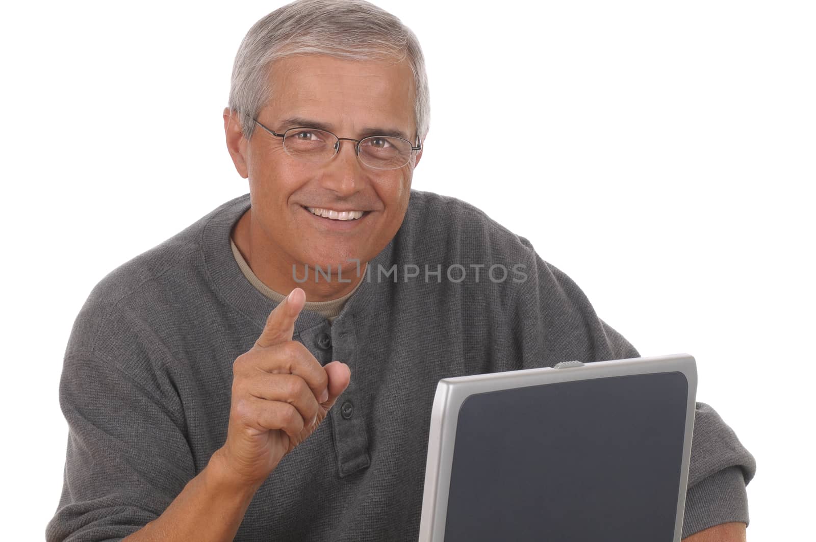 Middle aged man sitting at laptop computer and pointing at camera. Man is smiling and casually dressed. Horizontal format isolated on white.