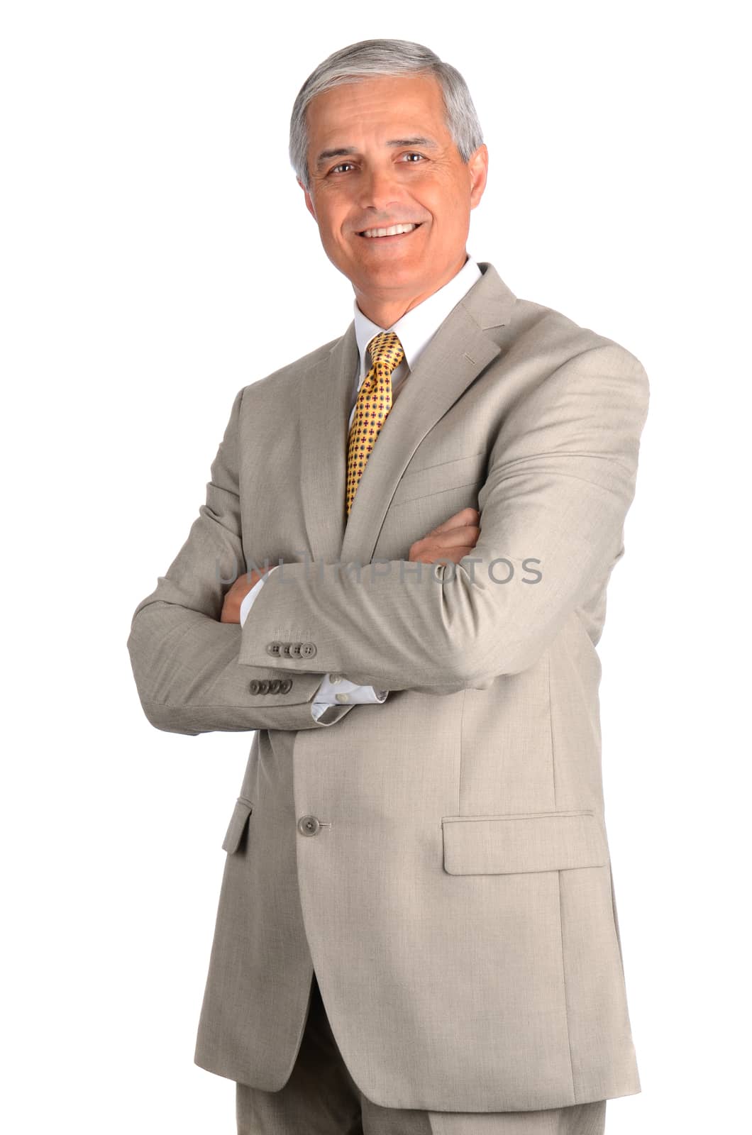 Portrait of a smiling middle aged businessman in a light suit with his arms folded. Three quarters view over a white background.