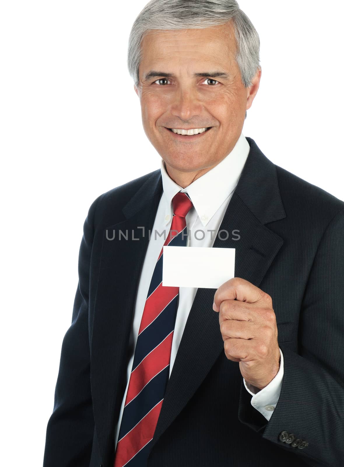 Portrait of a smiling middle aged business man holding a blank business card in front of his body. Vertical format isolated on white.