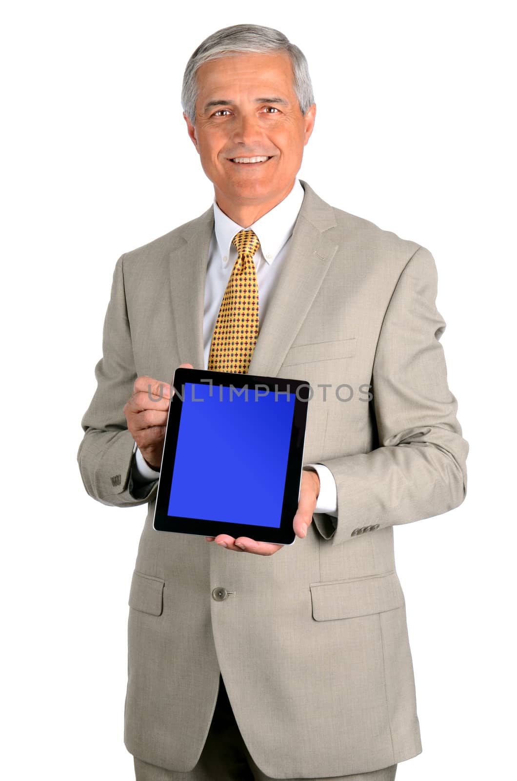 Portrait of a smiling middle aged businessman in a light suit with a tablet computer with display on blue screen. Three quarters view over a white background.