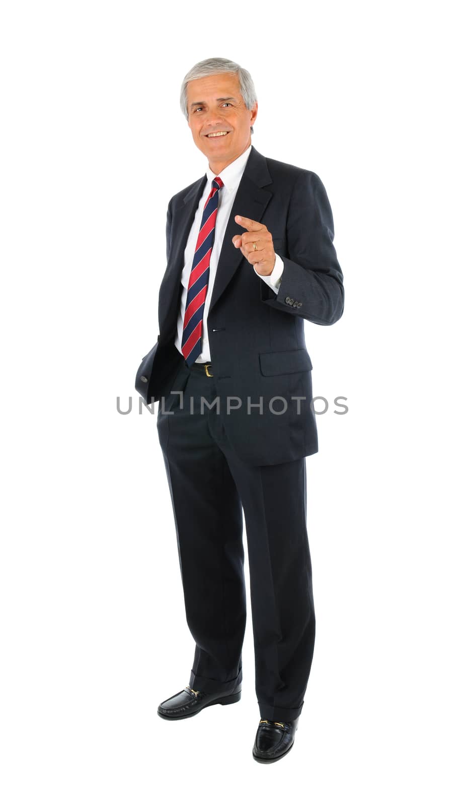 Smiling middle aged businessman standing and pointing with one hand and the other hand in his pocket. Full length over a white background.
