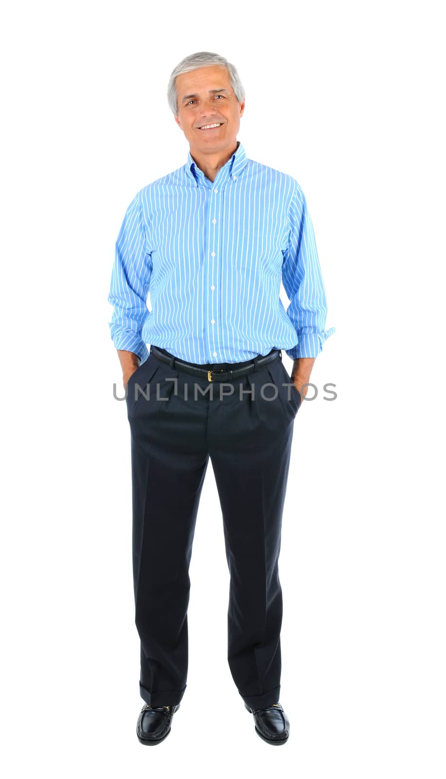 Smiling middle aged businessman standing with his hands in pockets. Full length over a white background.
