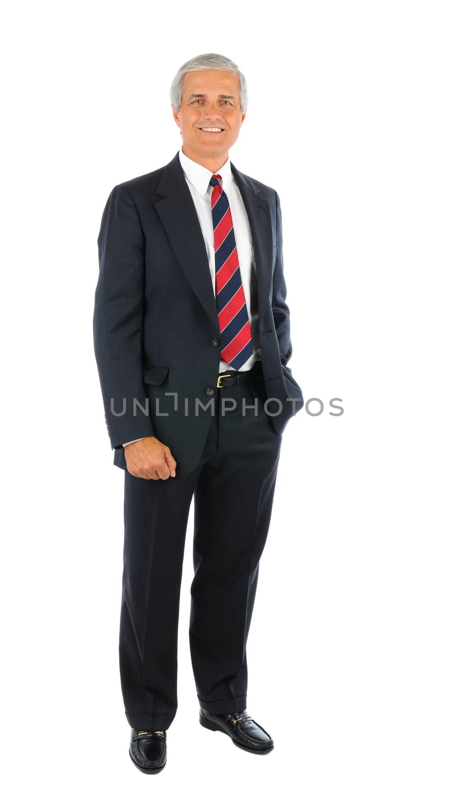 Smiling middle aged businessman in a suit and tie standing with one hand in his pocket and the other buy his side. Full length over a white background.